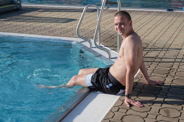 Man relaxing in swimming poll. 