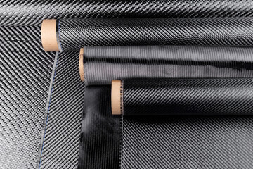 Rolls with various real woven carbon fiber enforcement raw material cloth. composite material industry high tech background.