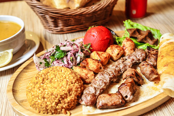 Wooden Plate With Meat and Vegetable Dish Served Alongside a Cup of Tea