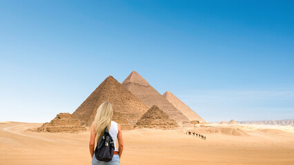 Giza, Egypt - A blonde haired woman looks at the pyramids in Giza, Egypt	