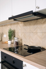 Integrated glass ceramic electrical hob and cooker hood at modern kitchen