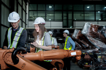 Fototapeta premium team engineers inspecting on machine with smart tablet. Worker works at heavy machine robot arm. The welding machine with a remote system in an industrial factory. Artificial intelligence concept.