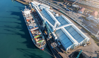 Fototapeta na wymiar Expansive aerial view of dynamic operations at a multipurpose industrial cargo terminal with ships and cranes
