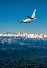 Fototapeta na wymiar A white wide body airplane approach in a resort mountain town