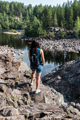 Girvas paleovolcano is a popular place among tourists. The concept of traveling around Russia. A tourist stands on frozen lava and enjoys the view of the lake. Back view.