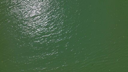 Background Looking down on peaceful river water with light breeze on surface with sunshine