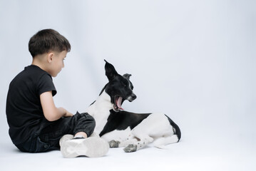 Child smiling at the camera while hugging his dog