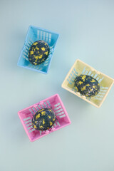 Easter eggs lie in a shopping basket. eggs are dark in color with yellow spots and white dots and stripes.