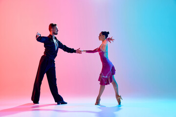 Elegance and tenderness. Young man and woman, ballroom dancers in motion, dancing, performing...