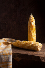 Two cobs sweet corn on wooden background..