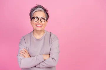 Fototapete Portrait of folded arms successful business woman retired age looking empty thoughtful brainstorming isolated over pink color background © deagreez