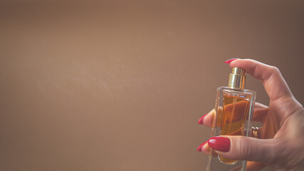 A woman holds a bottle of perfume in her hand. Close-up