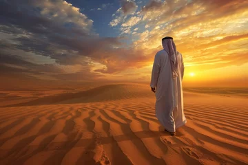 Gordijnen Arab man in desert watches sunset © The Big L