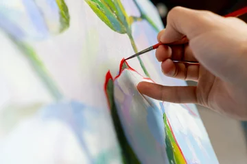 Fotobehang Schilderij close up in an art studio a painting with flowers the artist sitting the details on the painting with red paint  © Guys Who Shoot