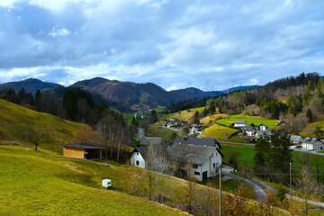 View of Poljanska dolina valley and buildings in Gorenja vas village and forest covered hill in Gorenjska, Slovenia © kato08