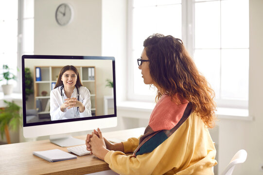 Sick woman listening recommendations and appointment having online video call with a female friendly smiling doctor using pc computer at home. Telemedicine and patient consultation online concept.