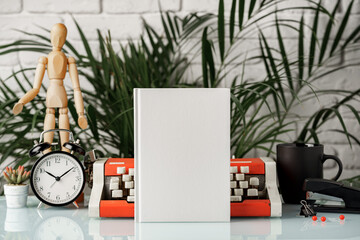 Hardcover book and vintage typewriter on white desk