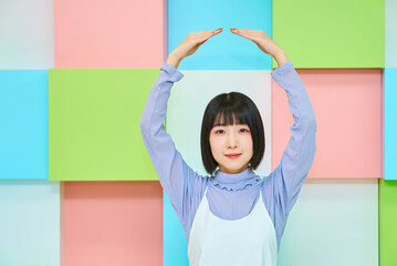 okのハンドサインをする若い女性とカラフルな背景