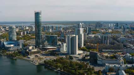 Top view of beautiful modern city with river on sunny day. Stock footage. Beautiful panorama of city with high-rise buildings on sunny summer day. Summer in modern city with skyscrapers and river
