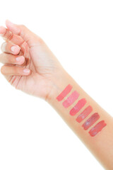 Foundation swatches on hand, woman holding makeup tube, testing different shades