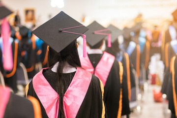 Graduation Ceremony with Students in Cap and Gown. Back view of graduates wearing caps and gowns...