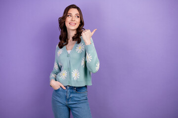 Photo of attractive model female in stylish clothes pointing finger showing promo offer mockup isolated on violet color background