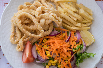 Calamares fritos con ensalada y patatas 