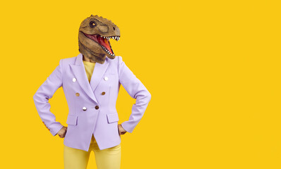 Funny crazy woman with reptile or dinosaur mask on her head isolated on yellow background. Stylish...