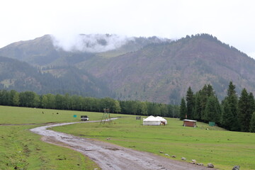 landscape near Jeti Oguz gorge with yurts and green meadows on a cloudy day