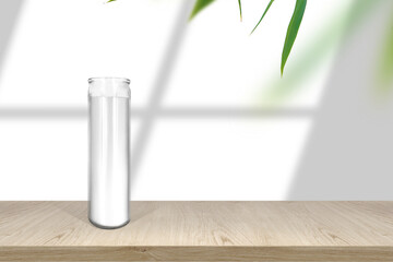 Classic white candle in glass mock up empty shelf with light and window- shadows with fresh leaves border