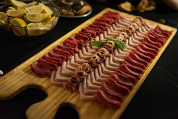Wooden board with chopped cold cuts. Charcuterie.