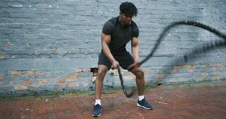 Outdoor fitness, black man and battle rope waves for intense workout, strength or resilience challenge. Power, energy and African athlete commitment to exercise, endurance and strong muscle building