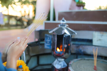 Burning incense sticks in the hands of a Buddhist monk.