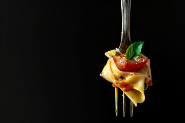 A fork with food on its prongs, showcasing a meal in progress.