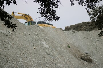 Equipment sit on top of  a 40 foot pile of removed dirt from the upgrades being given to I-635 Expressway,Dallas. 