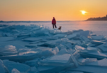 Woman and her dog are tourists in the background of Beautiful sunset arctic landscape with...
