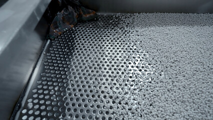 Cleaning of polymer granules. Creative. Mesh for cleaning white polymer granules from debris and...