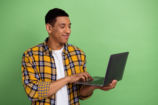 Photo of young experienced programmer python developer software engineer man using macbook laptop isolated on green color background