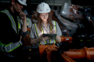 Business engineers meeting and checking new machine robot. Workers walking at warehouse industry...