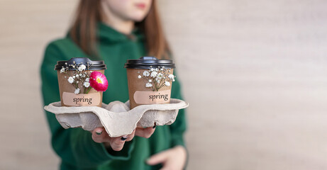 takeaway coffee with flowers attached to the cup with an adhesive plaster with the inscription...