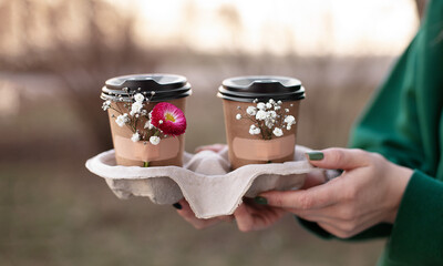 takeaway coffee with flowers attached to the cup with adhesive tape, spring coffee