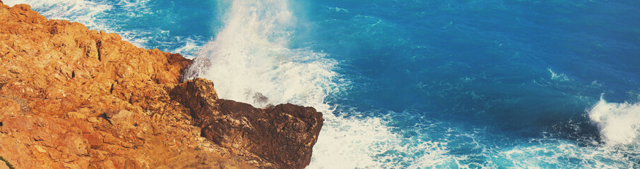 Rocky seashore. Stormy sea. Beautiful wild nature. Horizontal banner