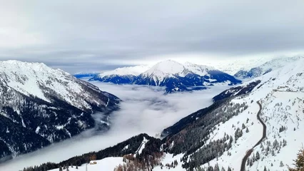 Fotobehang Jaufenpass, South Tyrol - Italy - View of the snow-covered Passeier Valley with a cloud cover © Bärbel