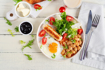 English breakfast. Keto breakfast. Fried egg, beans, chicken sausage and coffee cup. Top view, flat lay