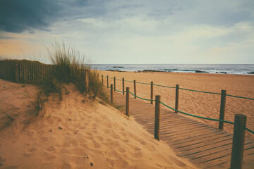 Wooden walkway on the sandy beach at sunset. Beautiful beach in the evening. Atlantic ocean. Porto, Portugal