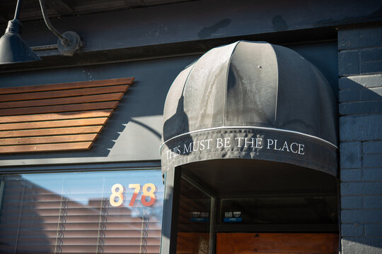 quarter round awning canopy cover over entrance with text "This Must Be The Place" (Civil Liberties, a cocktail bar) located at 878 Bloor Street West in Toronto, Canada