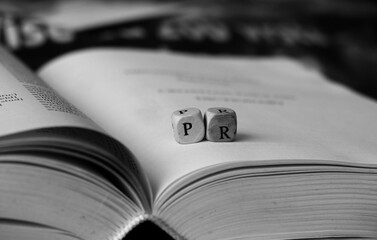 Public relations letters on open book - Powered by Adobe
