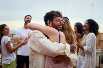 A group of people is joyfully embracing greet each other in a gesture of happiness and unity at a lively party. Together they are sharing a moment of fun and entertainment. Concept of friendship