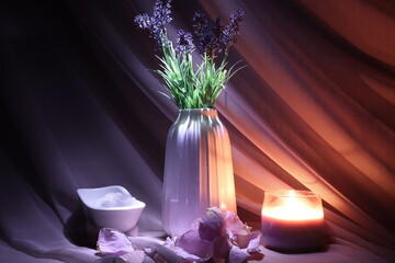 Spa still life for relaxation. Candle, lavender and delicate pink flower petals