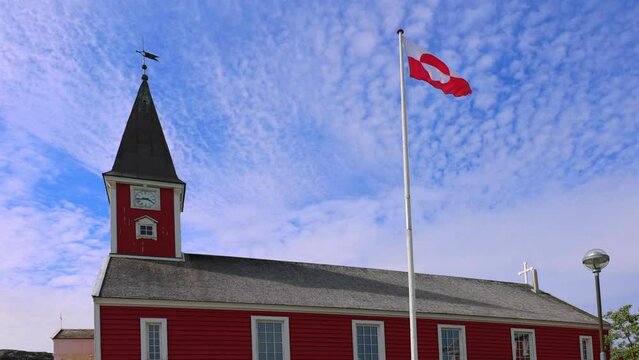 Greenland flag waving over the main Nuuk cathedral, downtown capital church.